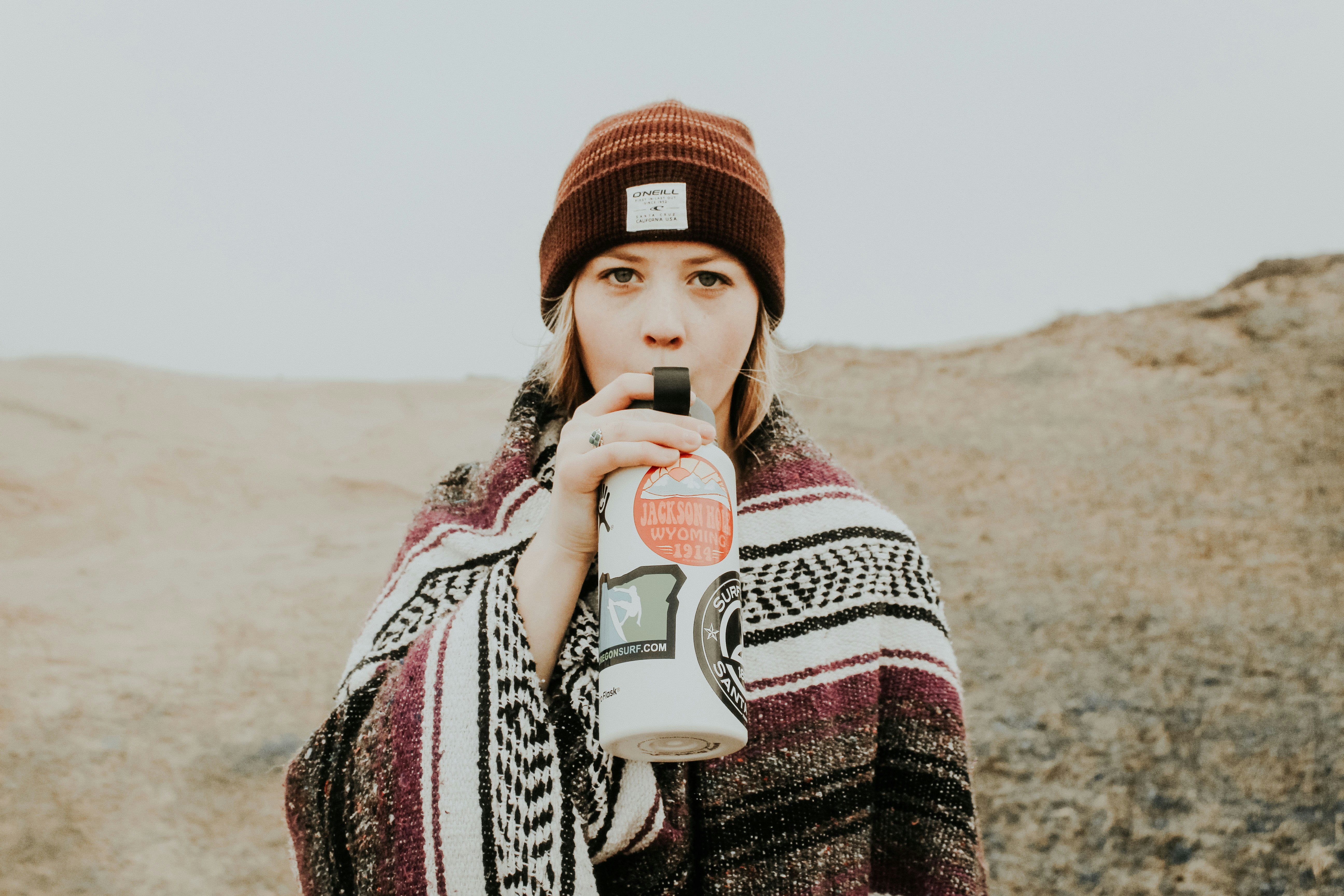 woman holding white and black tumbler